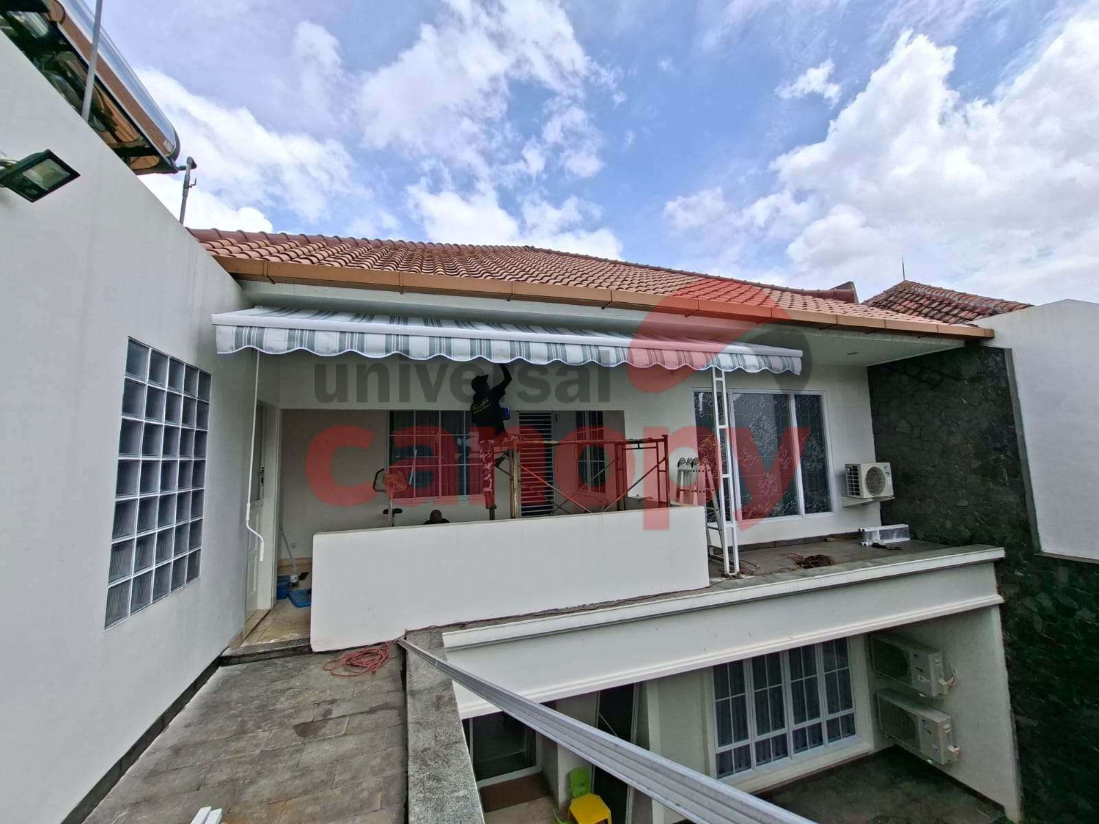 Retractable awning motorized terpasang di teras kafe di Bandung dengan kain Dickson premium